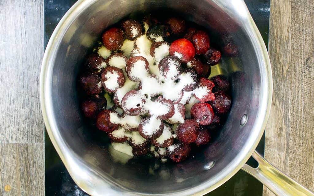 frozen cherries and sugar in a pot