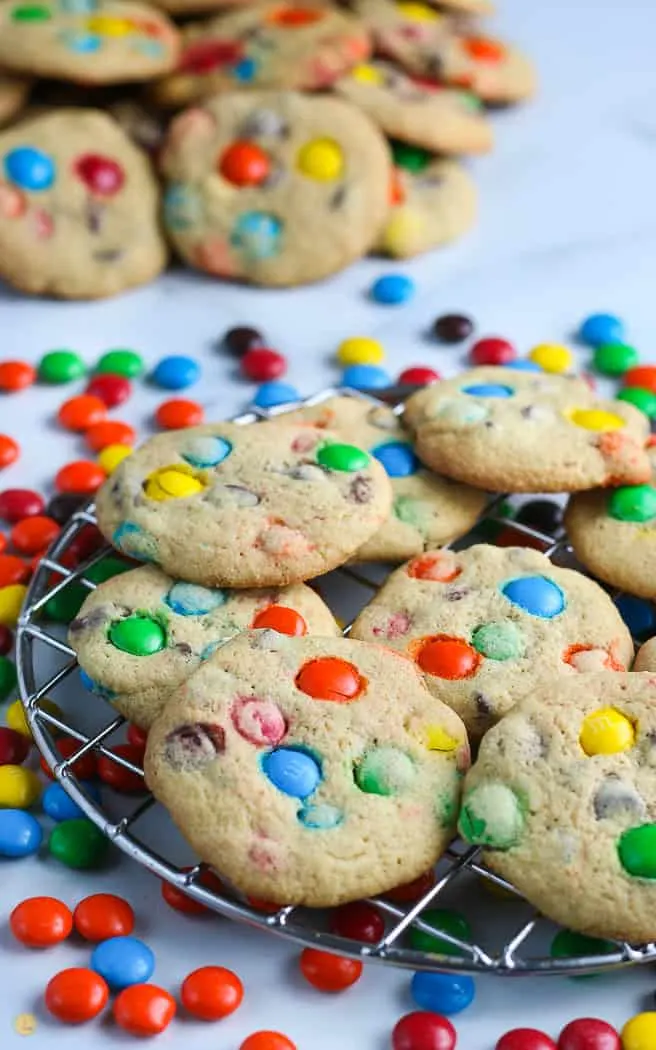 side pick of M&M cookies on a wire cooling rack with candy spread around it