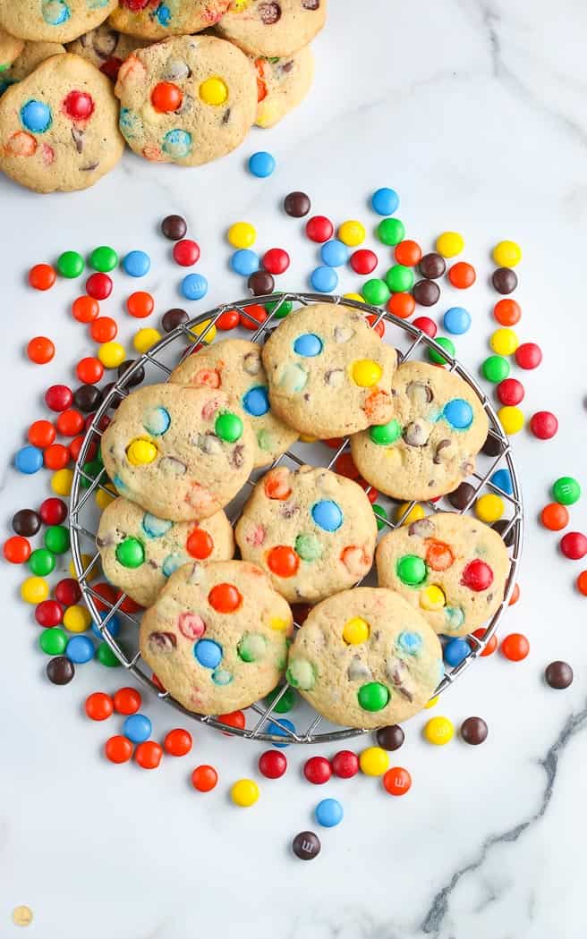 overhead pic of M&M cookies on a wire cooling rack with candy spread around it
