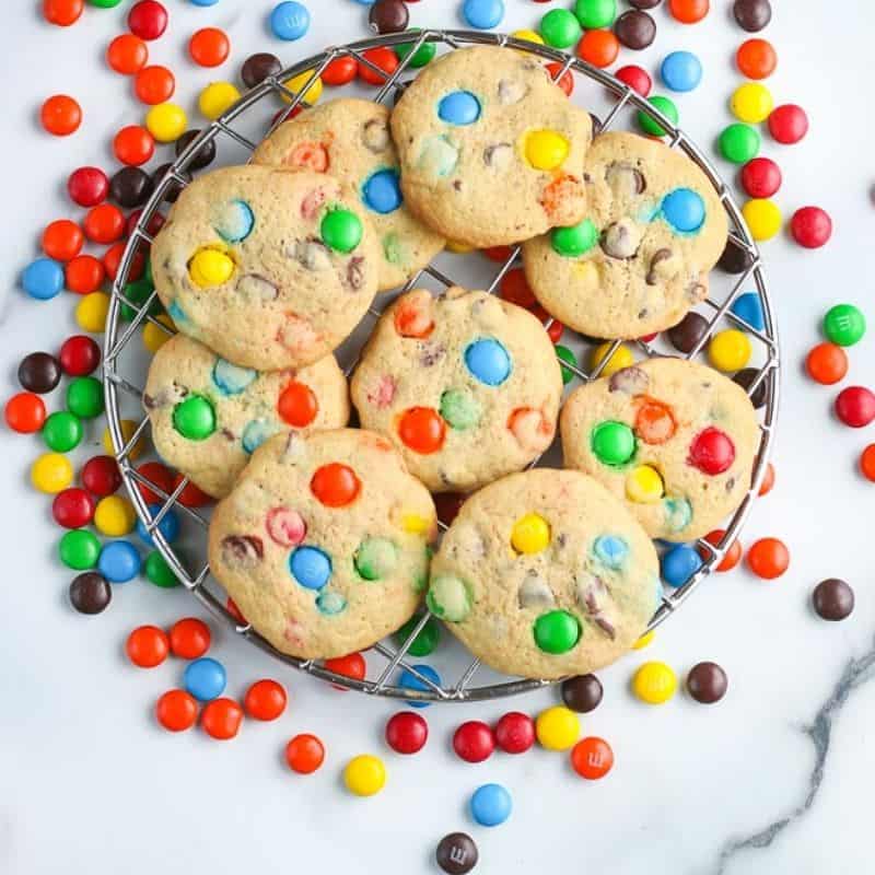 overhead square pic of m&M cookies on a metal rack
