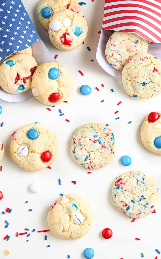 overhead shot of patriotic cookies in red white and blue bags surrounded by festive sprinkles