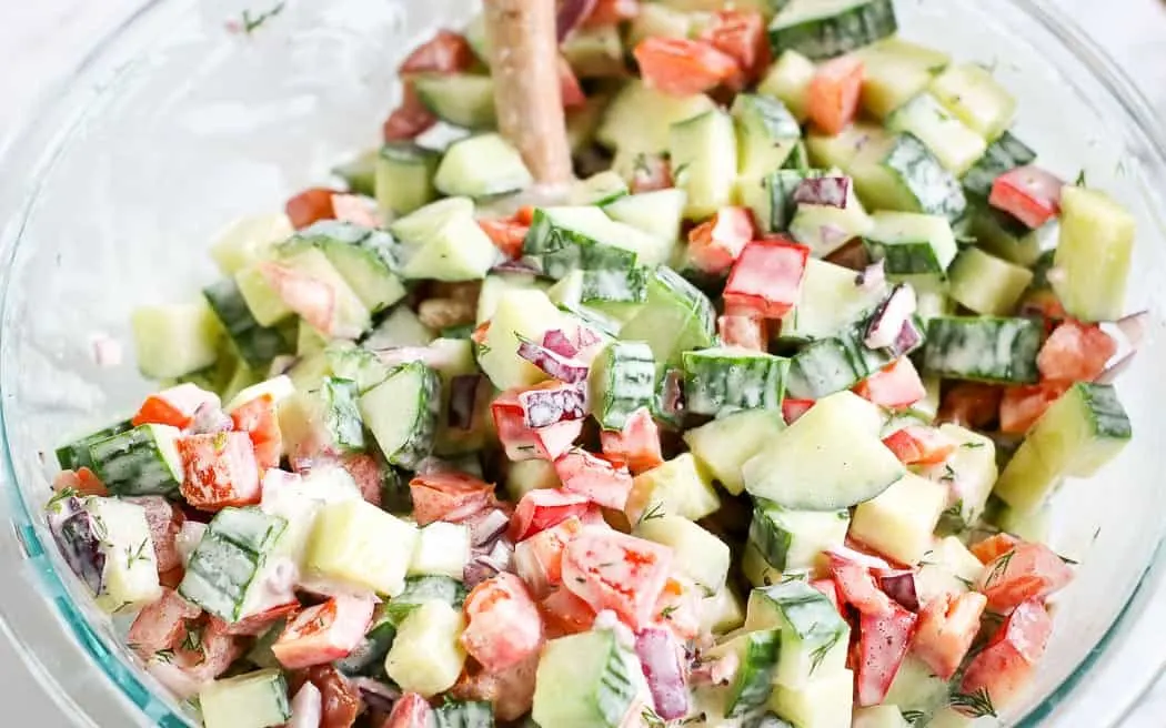 mixed chopped cucumber tomato salad in a clear bowl