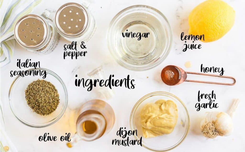 labeled ingredients for homemade italian dressing on a marble background