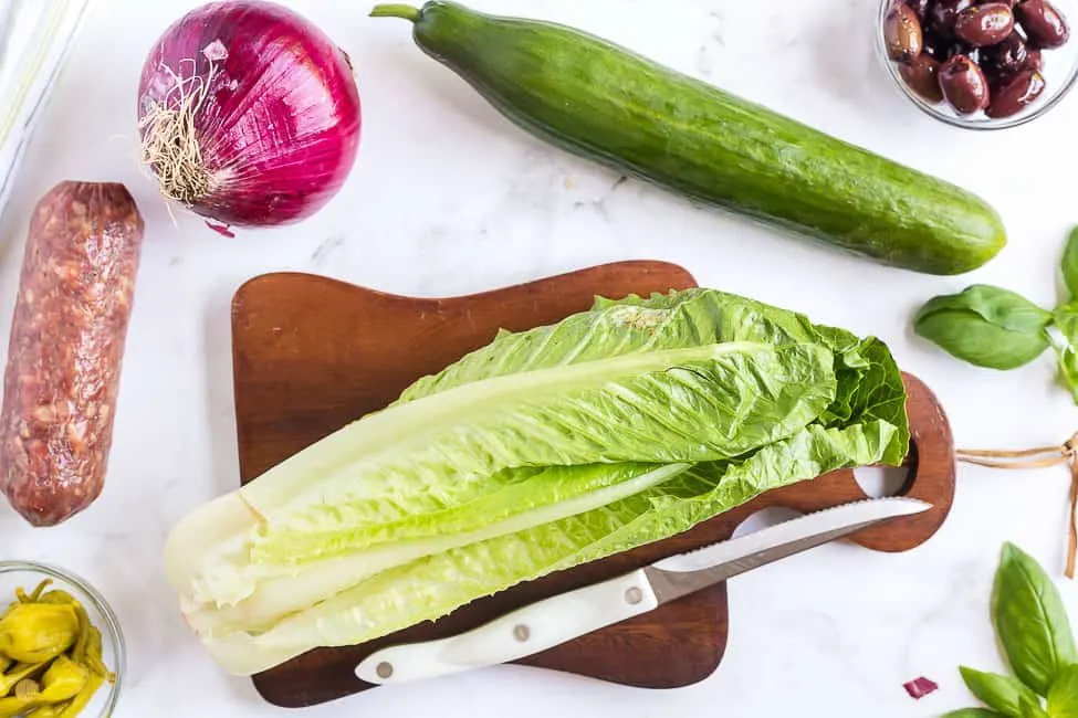 head of romaine lettuce and a knife on a cutting board