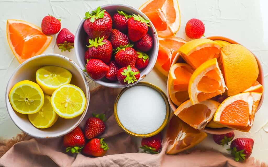 fresh fruit in individual bowls with a bowl of sugar