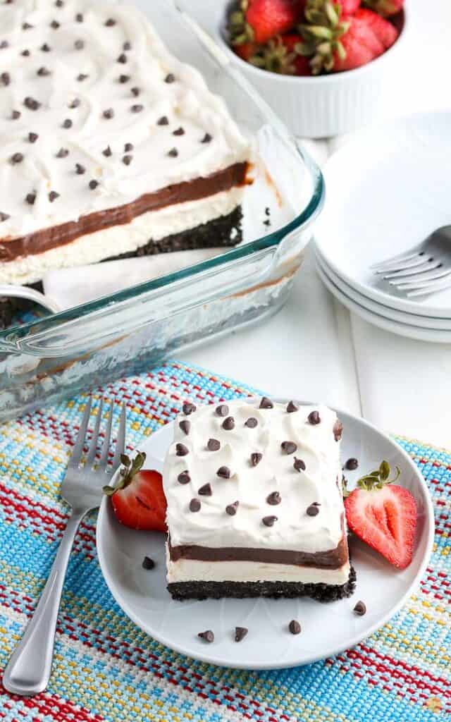 overhead picture of a slice of chocolate lasagna on blue plate next to full dish