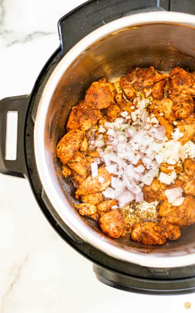 chicken, onion, and garlic cooking in an instant pot