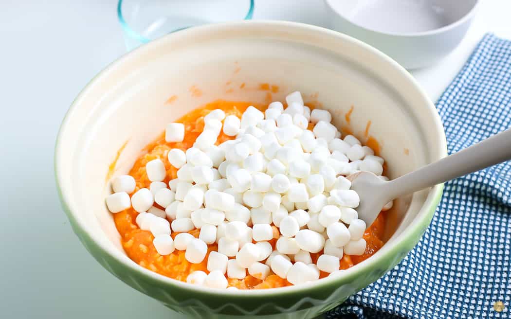 mini marshmallows on orange jello salad in a bowl