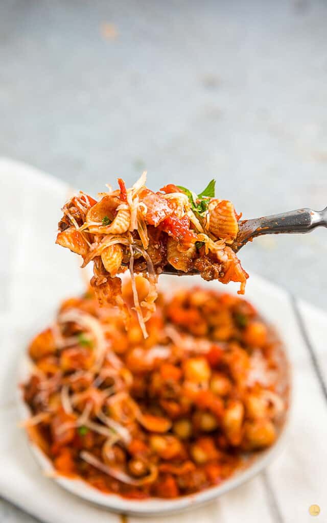 a fork full of beefaroni over a full bowl