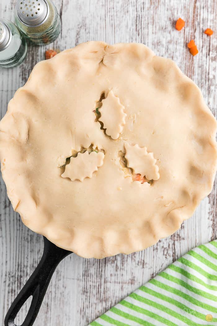 uncooked chicken pot pie in a skillet on a white backdrop