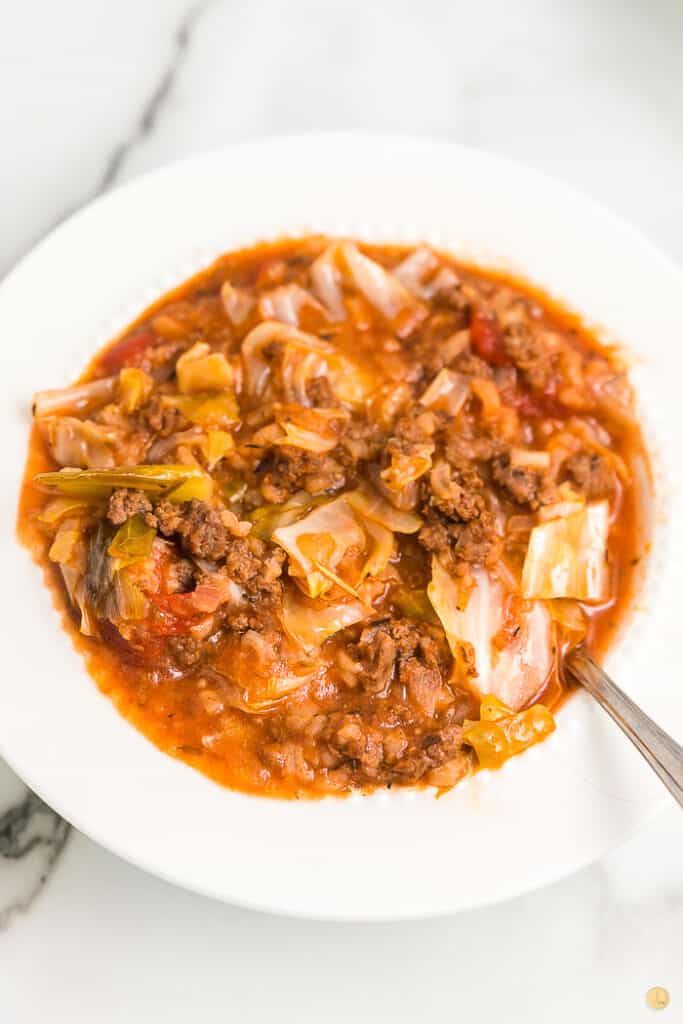 white bowl with cabbage soup and spoon