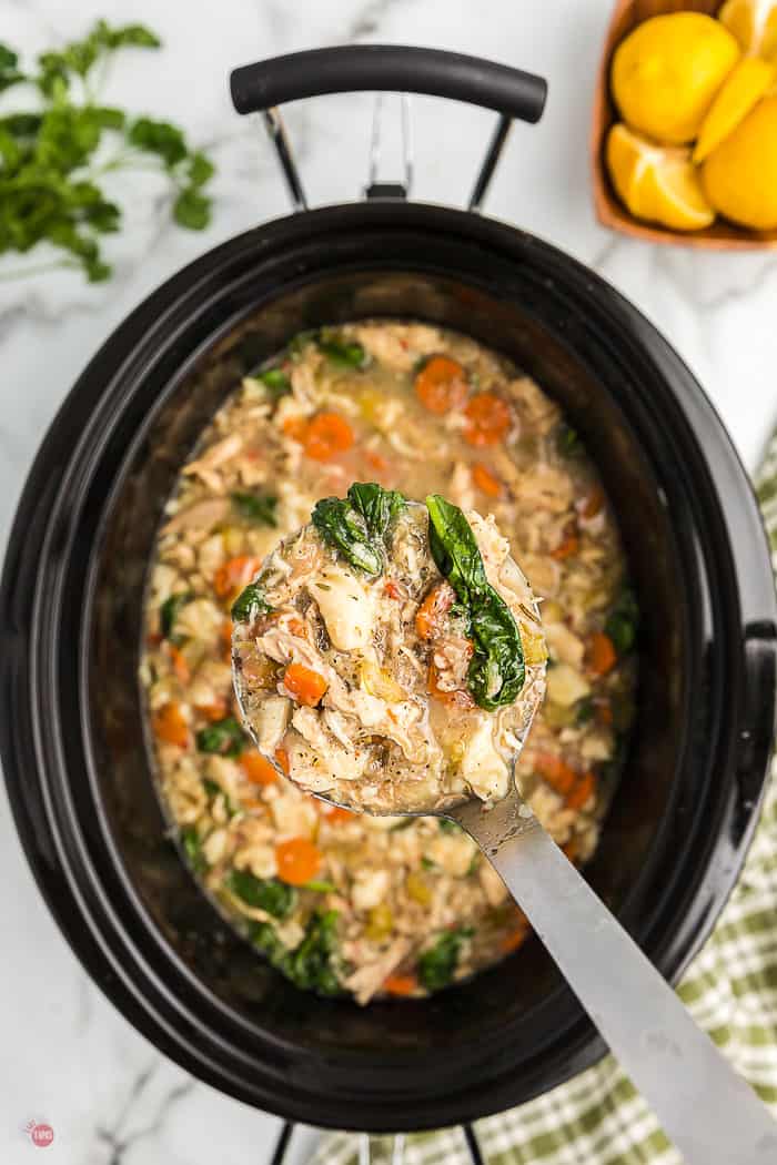 ladle of soup over slow cooker bowl