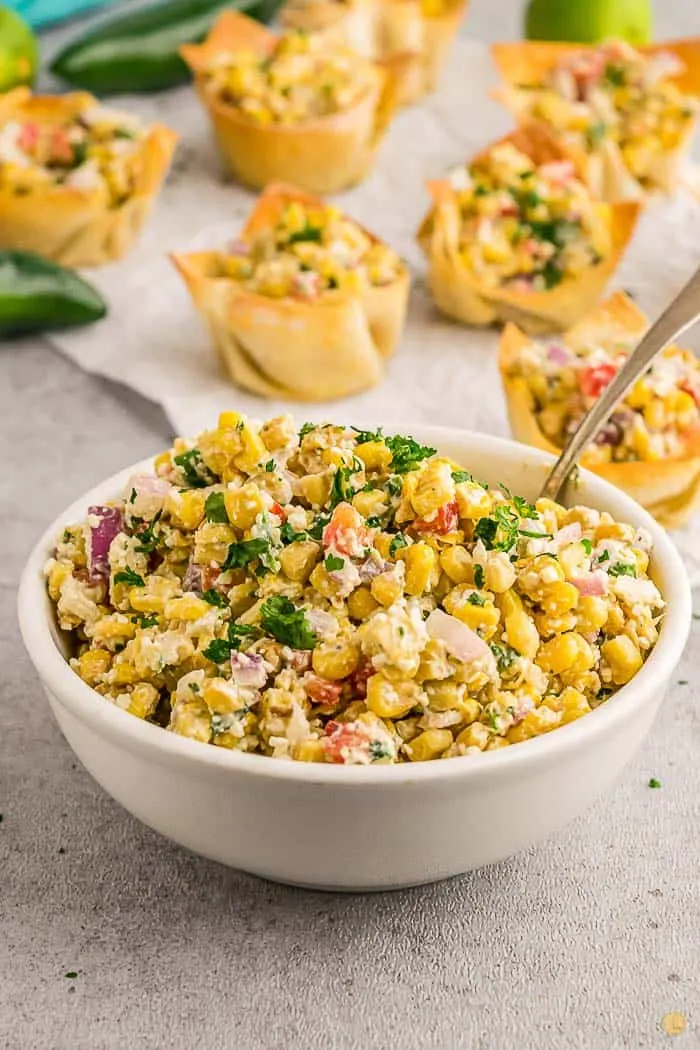 street corn in a bowl with a spoon