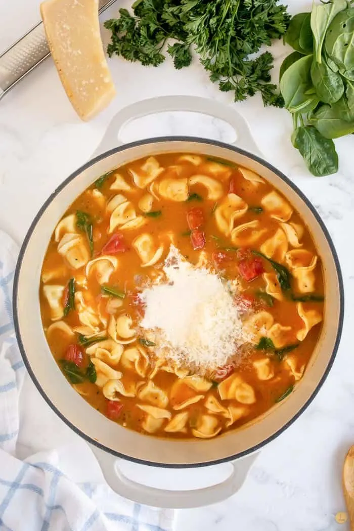 tuscan tortellini soup in pot with cheese