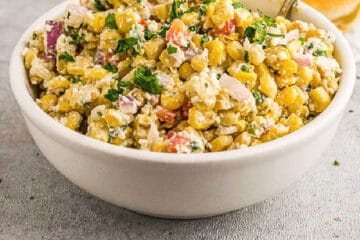 square photo of corn salad in a white bowl