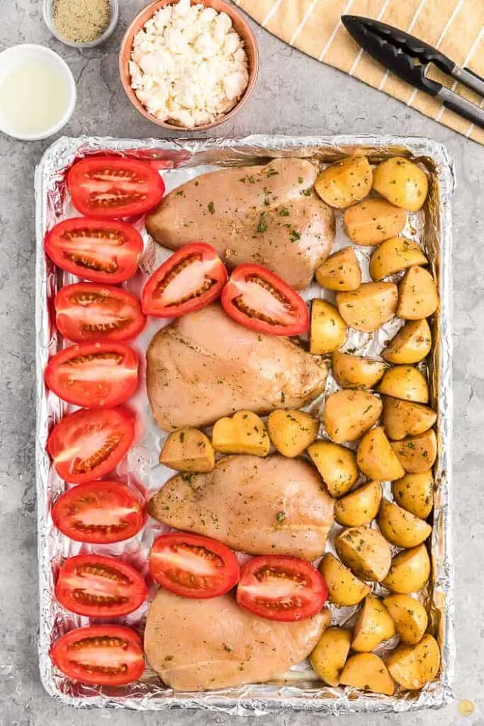 chicken potatoes and tomatoes on a sheet pan