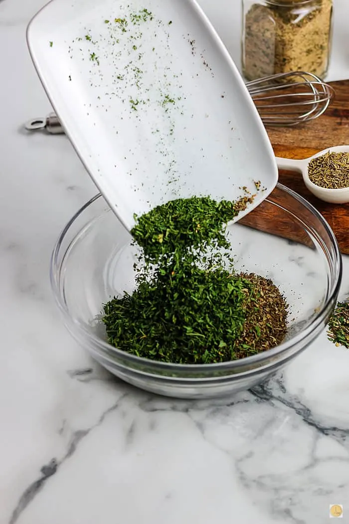 green herbs pouring into a bowl