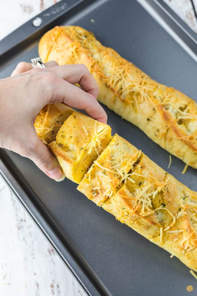 hand grabbing garlic bread