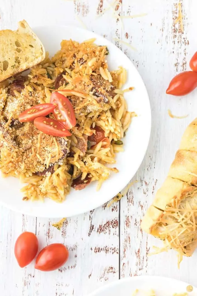 baked cajun pasta on plate with garlic bread