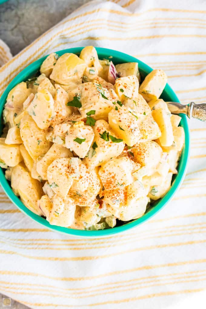 overhead picture of potato salad in a blue bowl