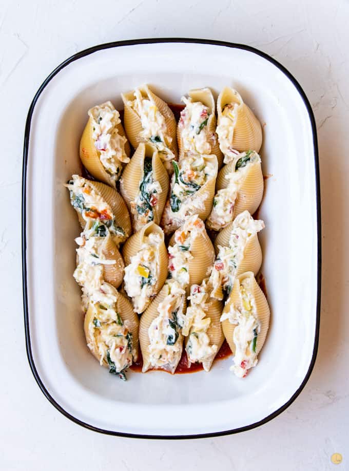 uncooked stuffed shells in baking dish
