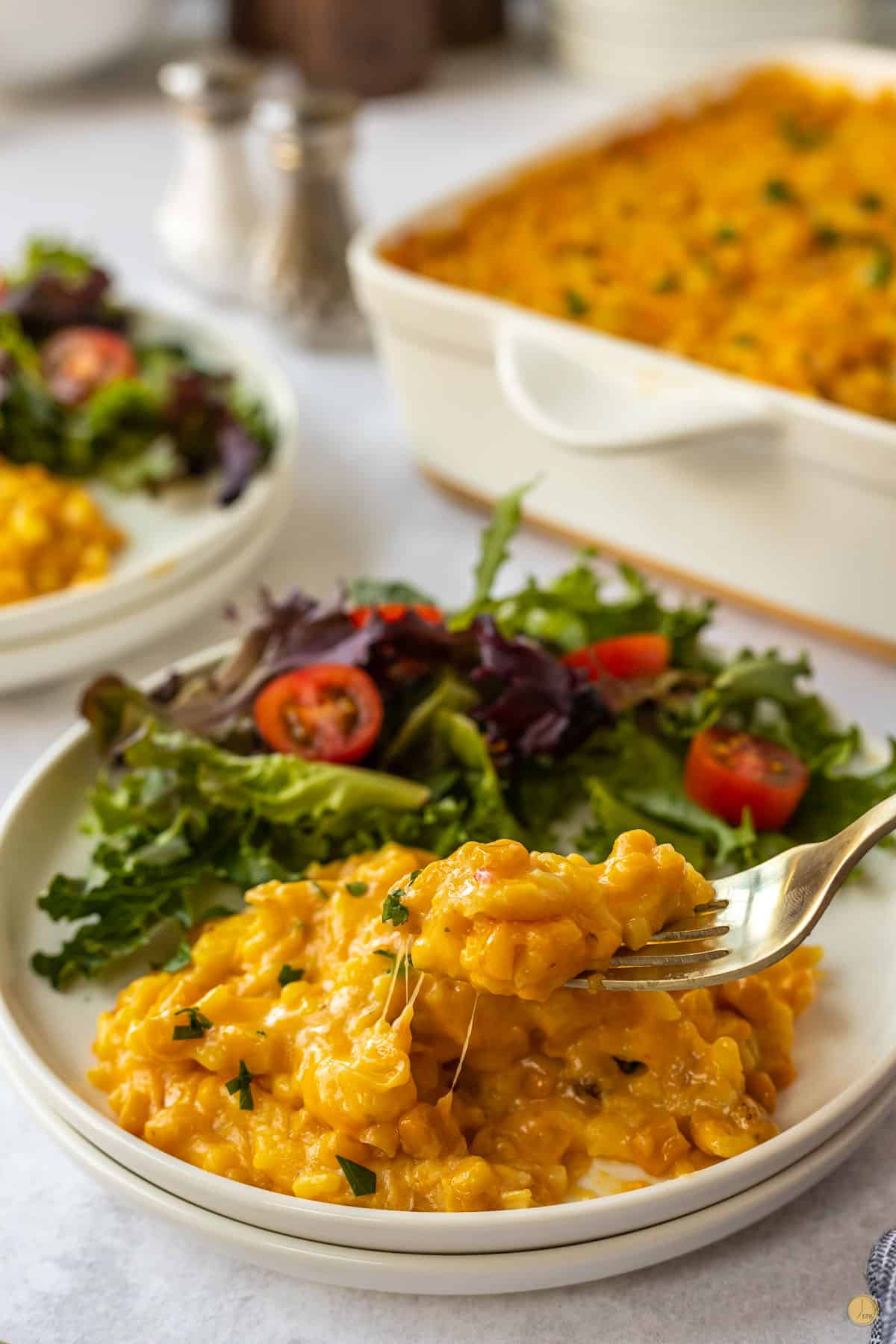 plate of corn and rice casserole and salad