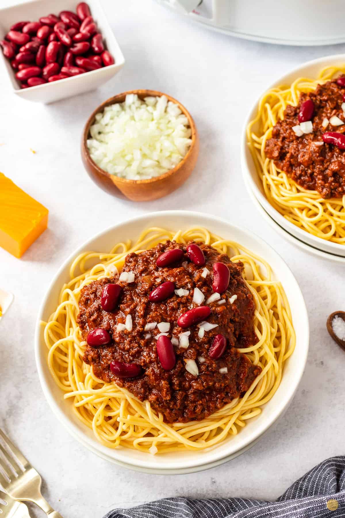 bowl of chili, spaghetti, beans, and onion
