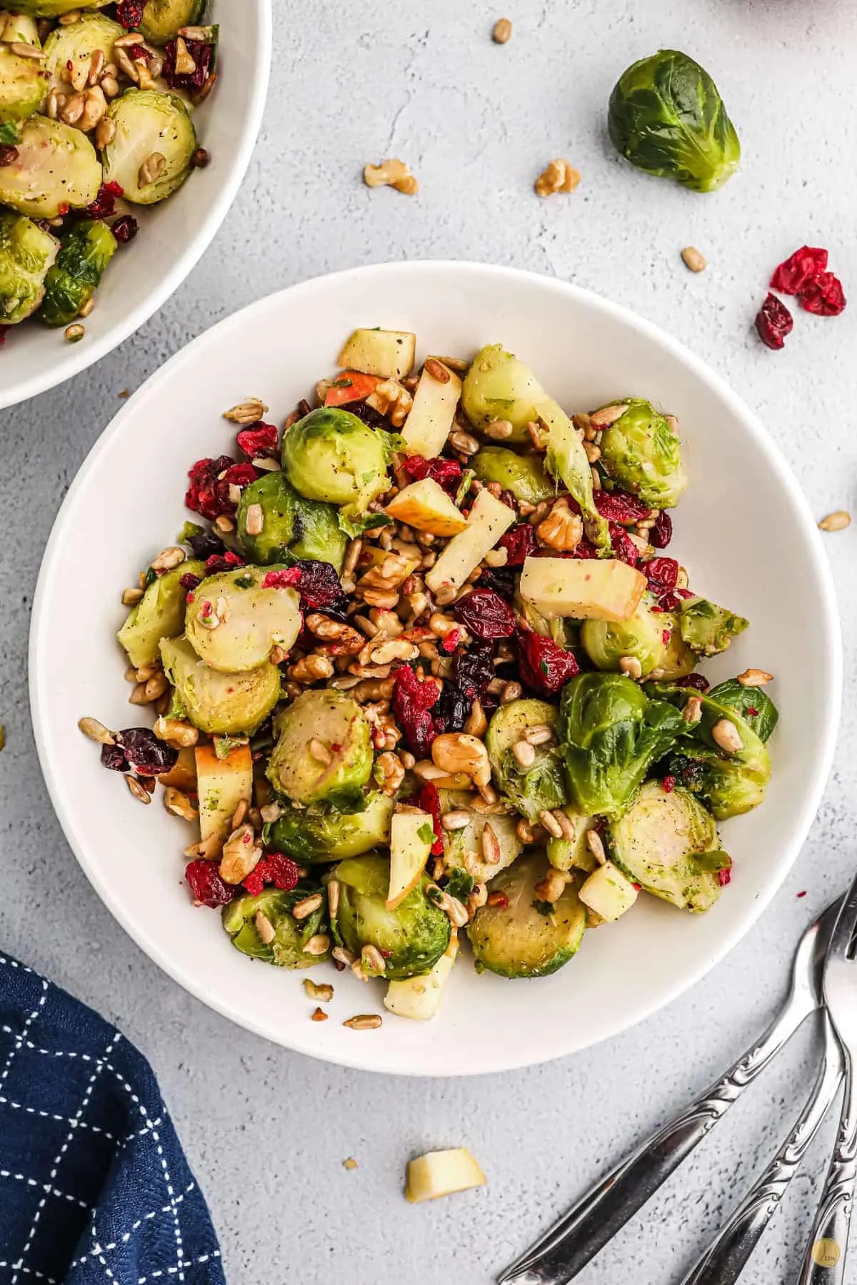 Brussels sprouts salad in a white bowl on a table. 