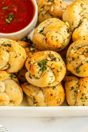 bowl of garlic knots with tomato sauce