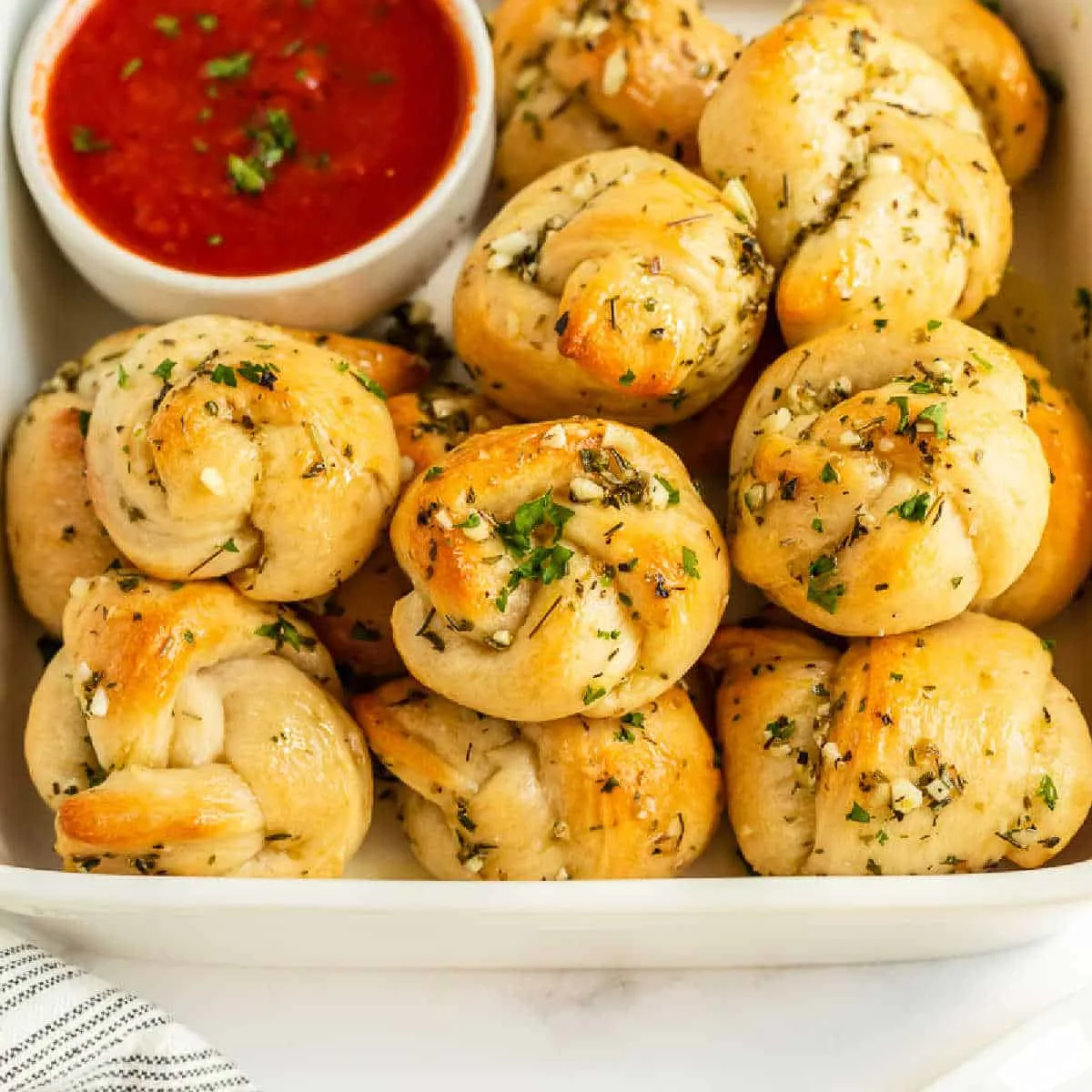 bowl of garlic knots with tomato sauce