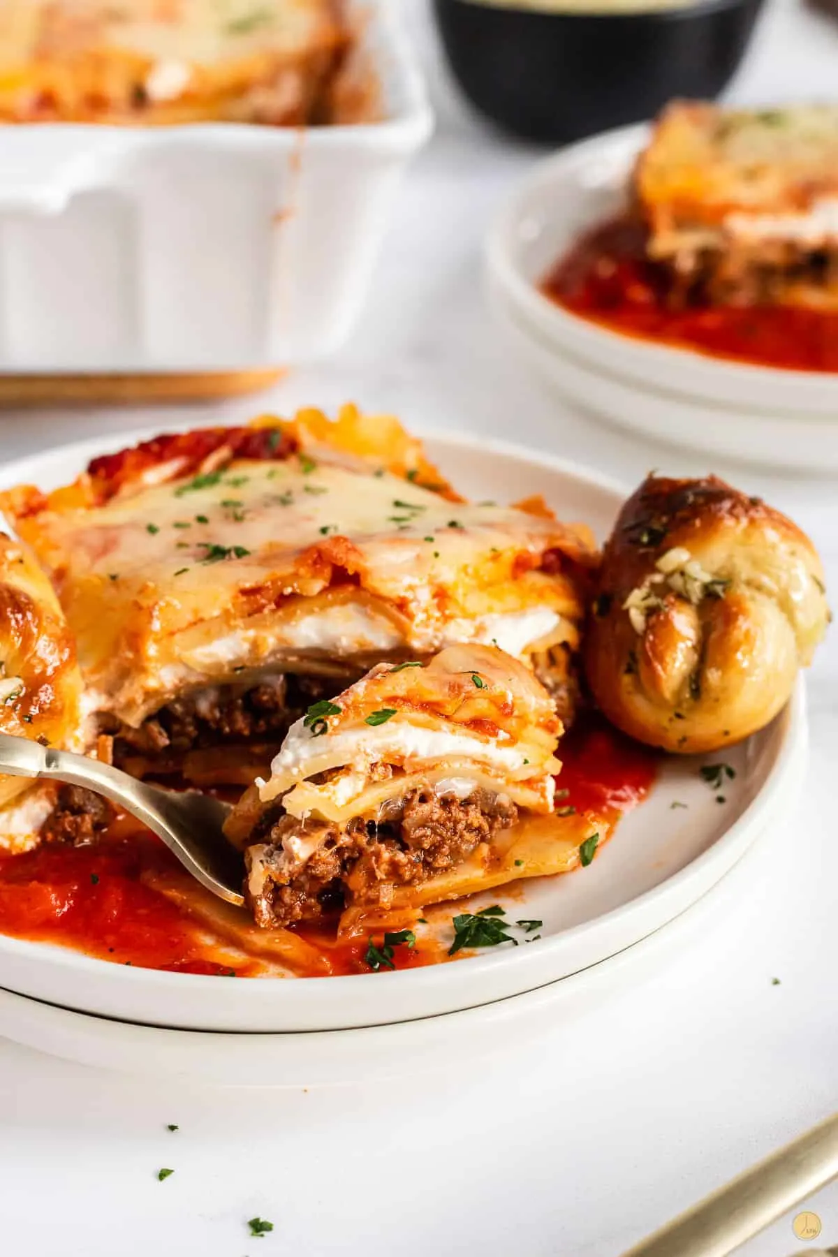 slice of lasagna on plate with fork