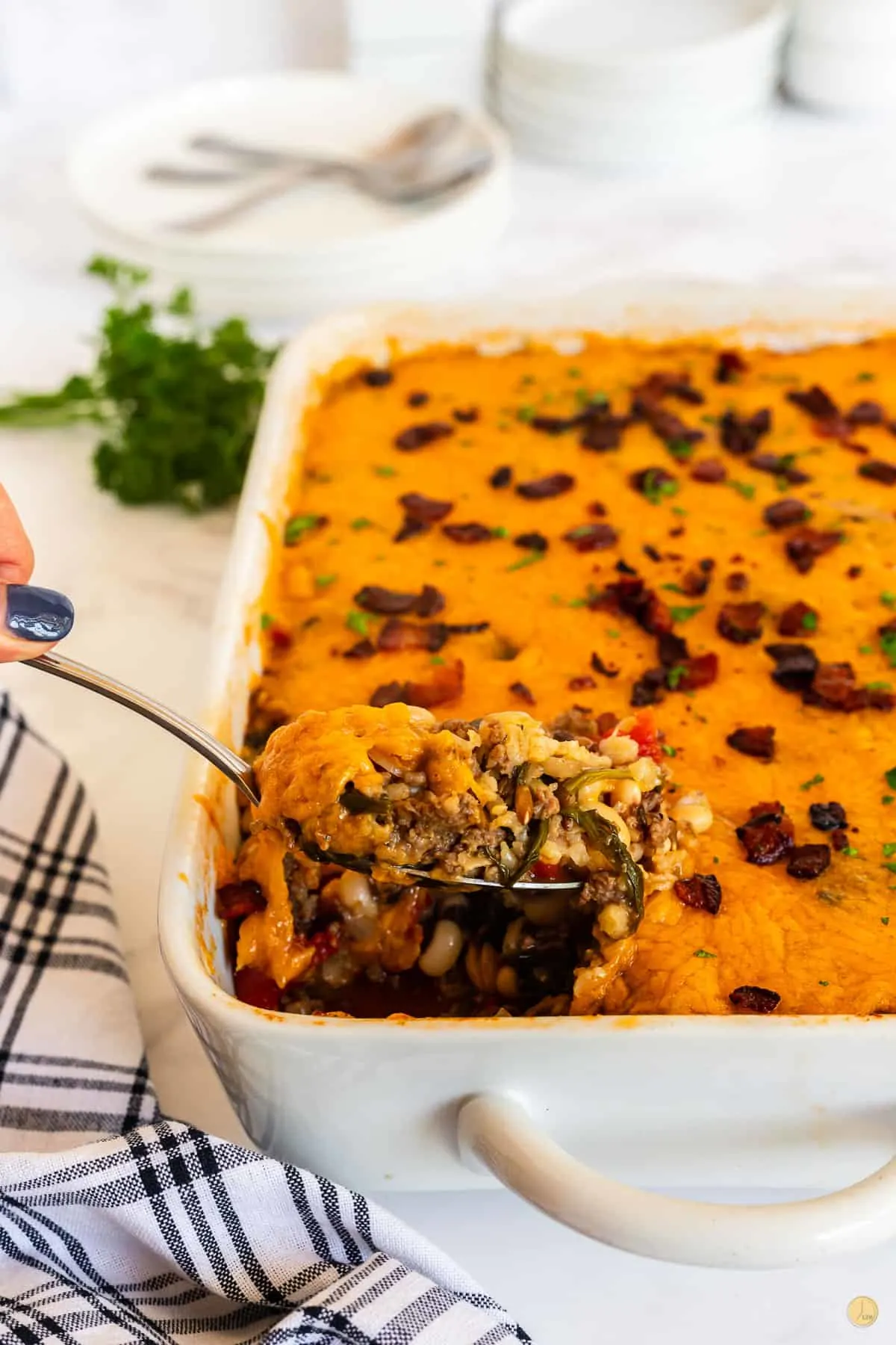 black eyed pea casserole in a white dish with spoon