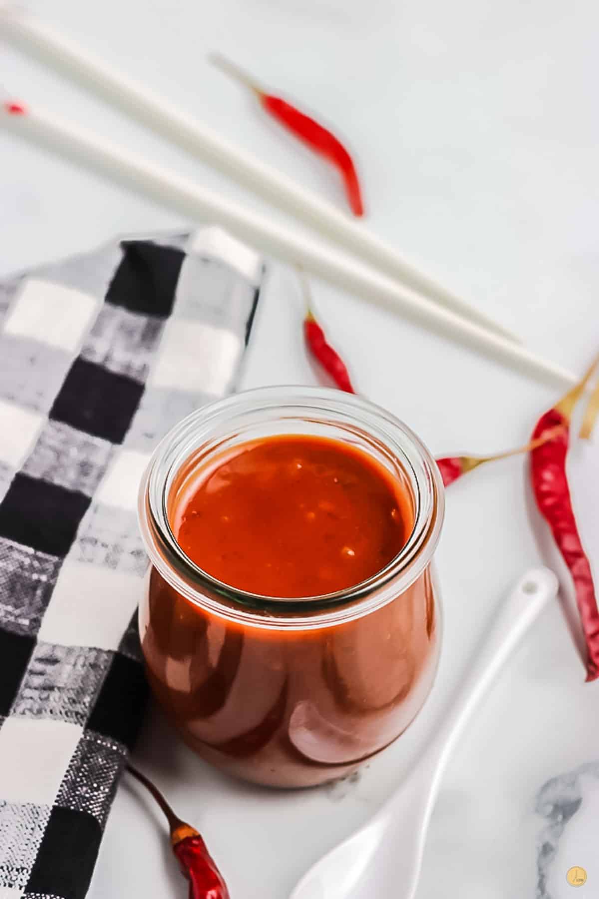 jar of sauce with peppers and chop sticks