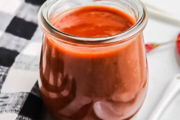 close up of jar of sauce on black and white napkin
