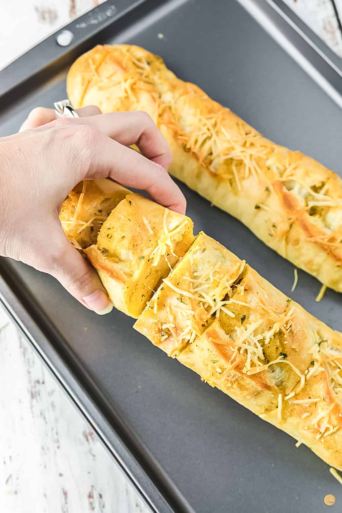 hand grabbing garlic bread