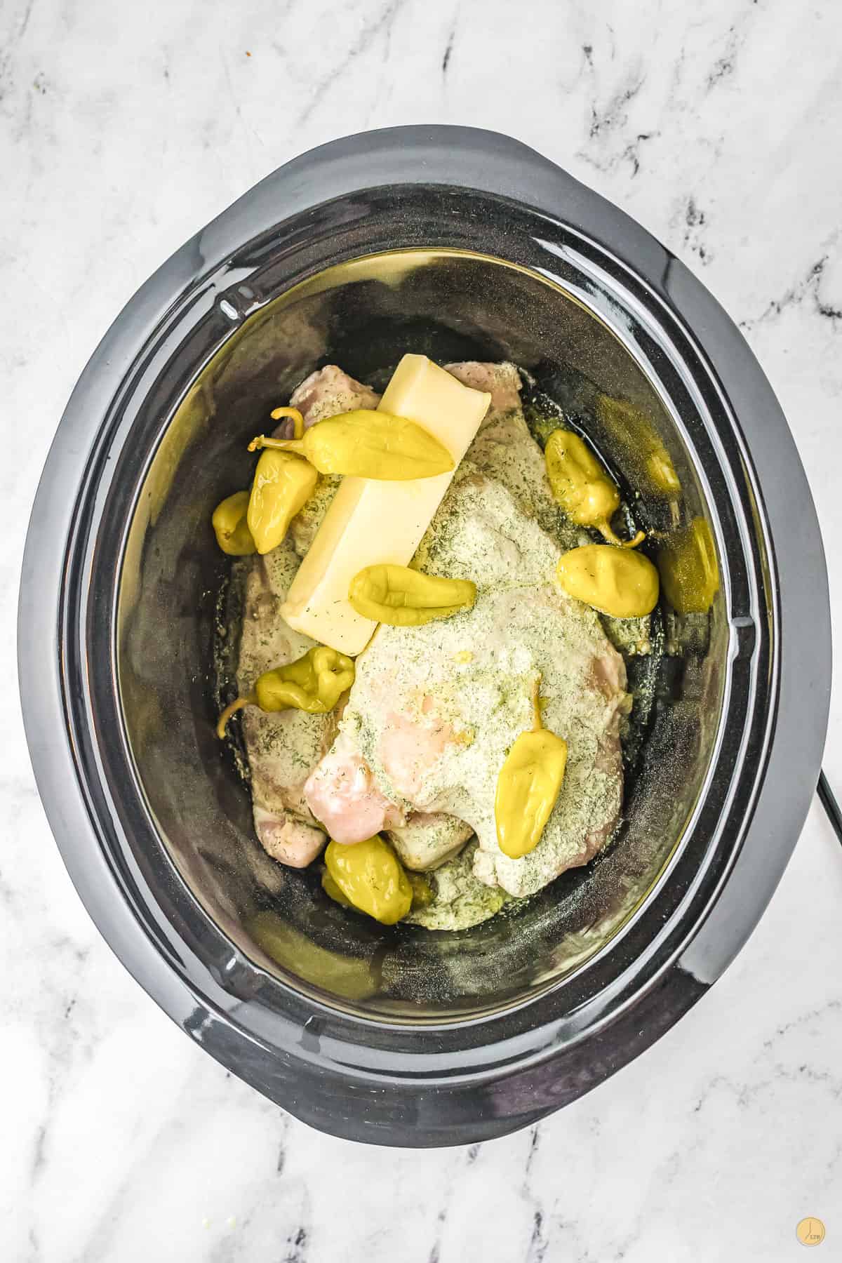 butter and peppers in a slow cooker