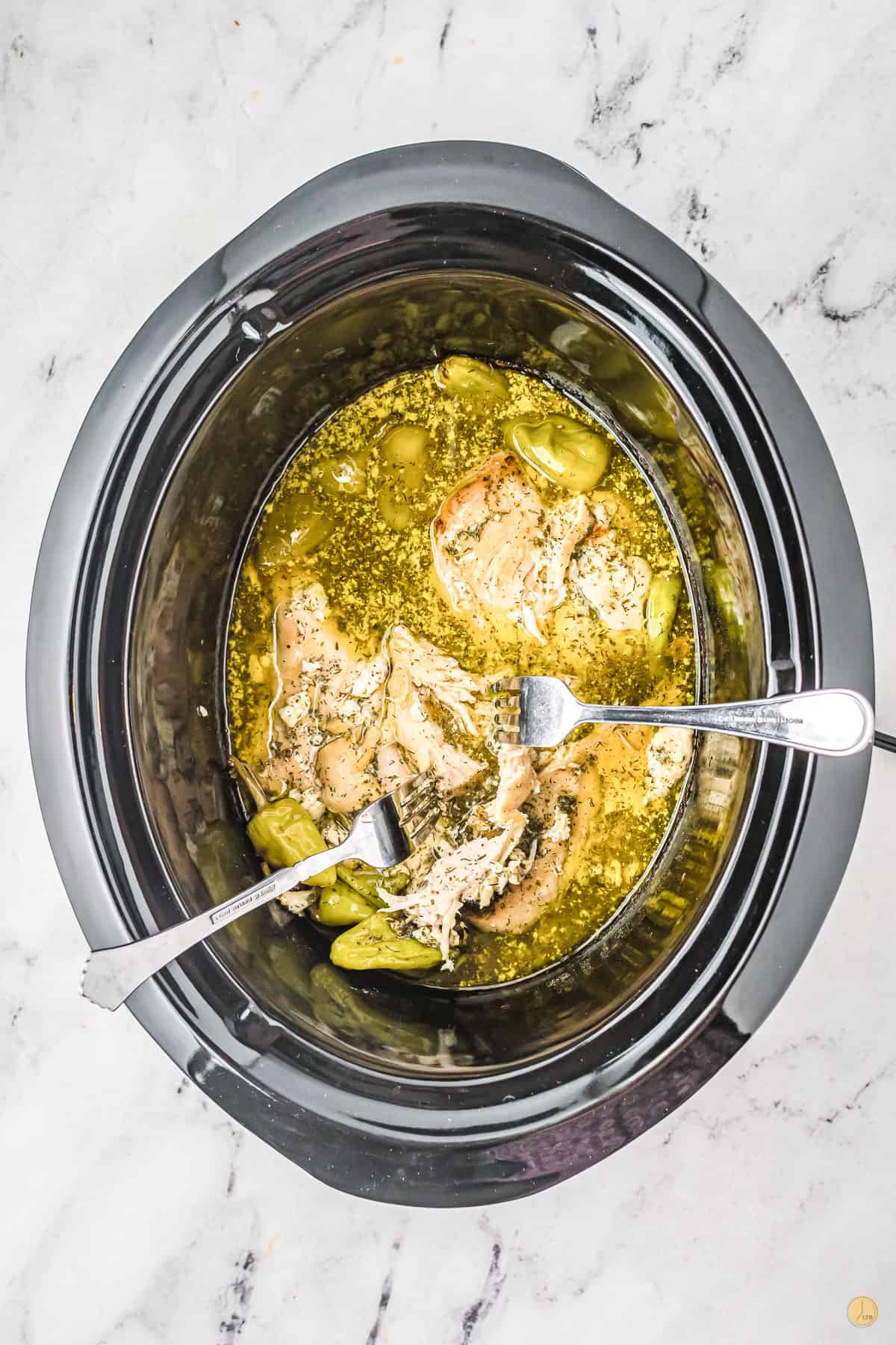 cooked chicken and butter in a slow cooker