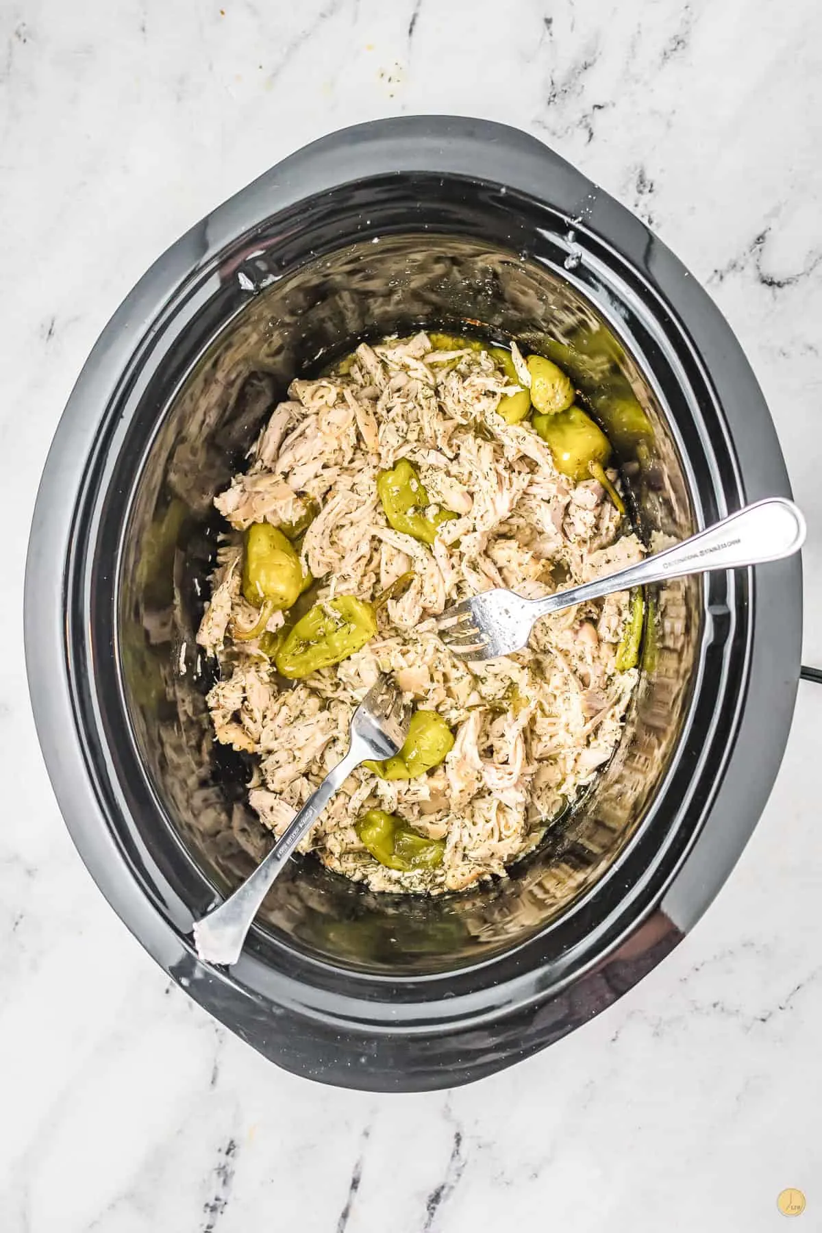 slow cooker with chicken and two forks