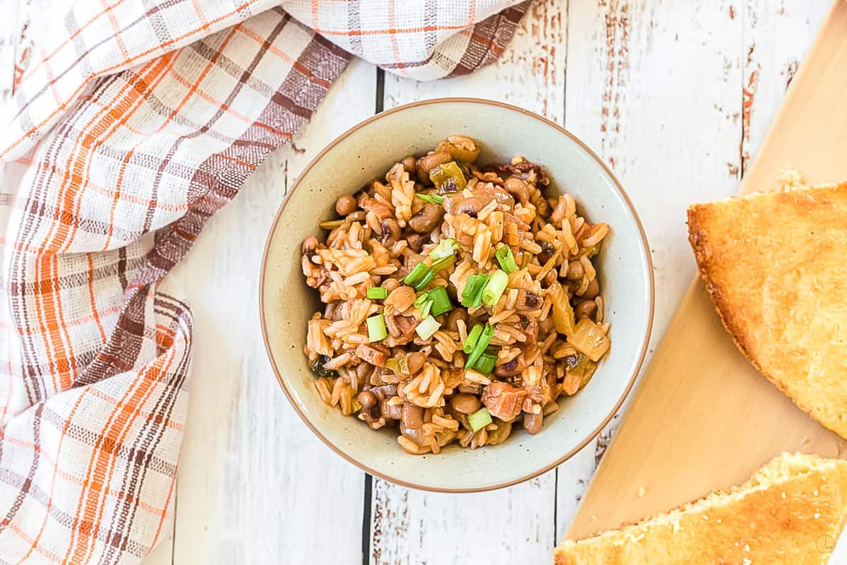 hoppin john in a white bowl with bread