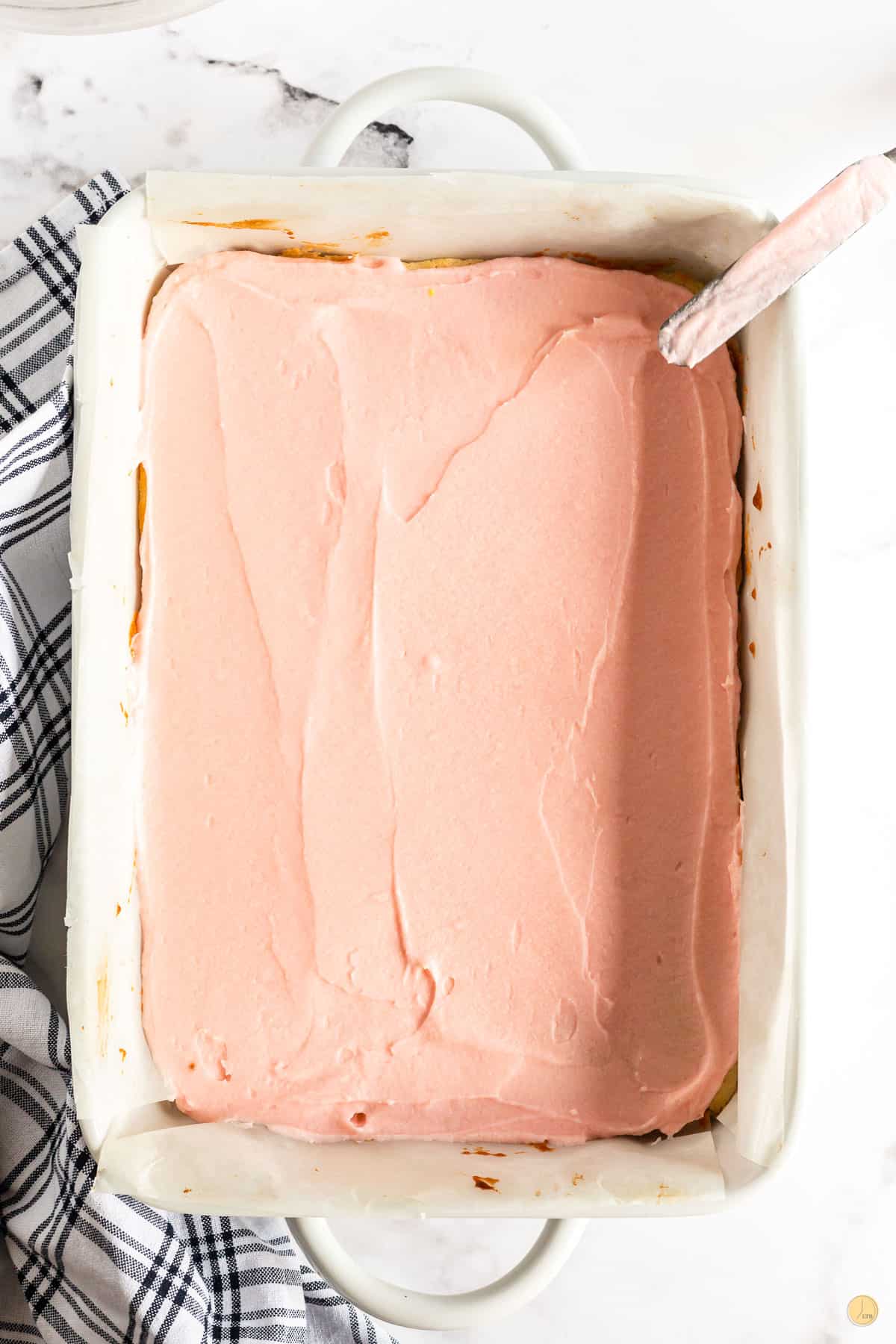 pink frosting over bars in a pan