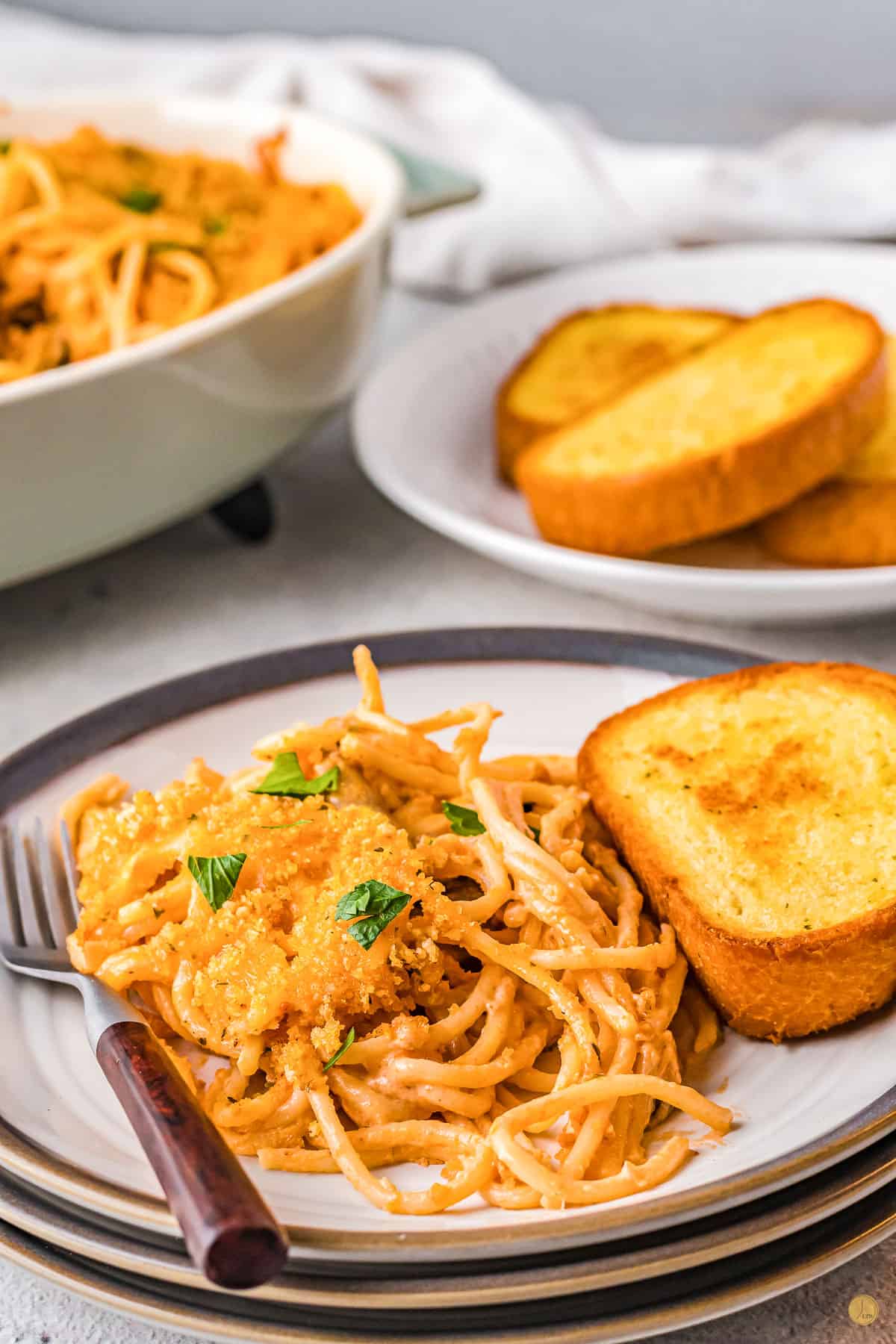 two plates of pasta with garlic bread