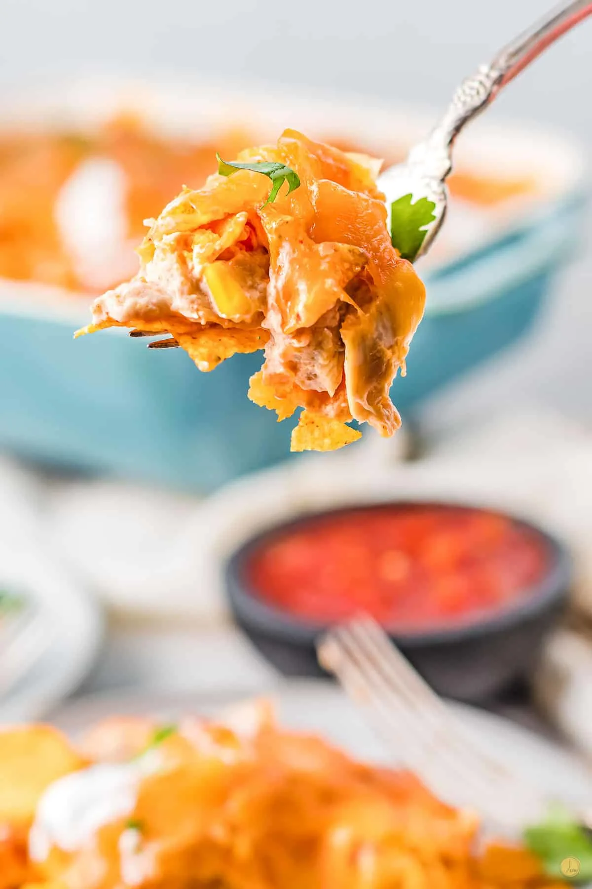 fork of chicken casserole over a bowl of salsa