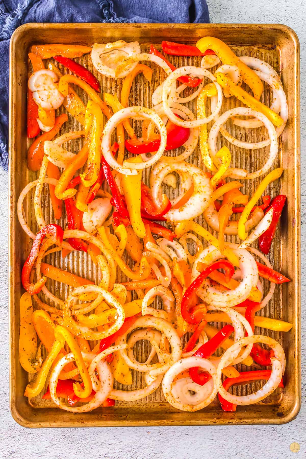 sausage peppers and onions on a baking sheet
