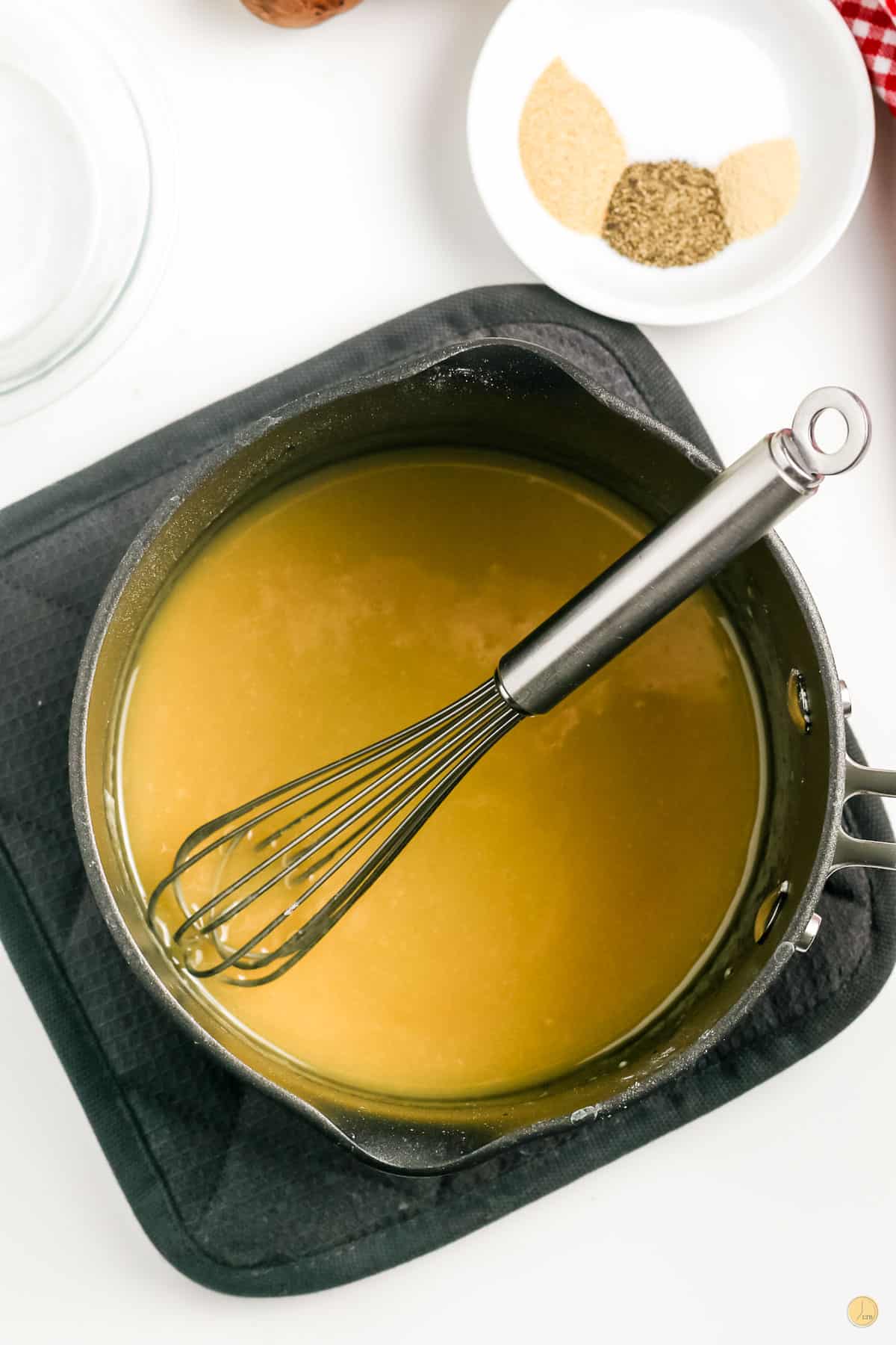 soup in a pot with a whisk