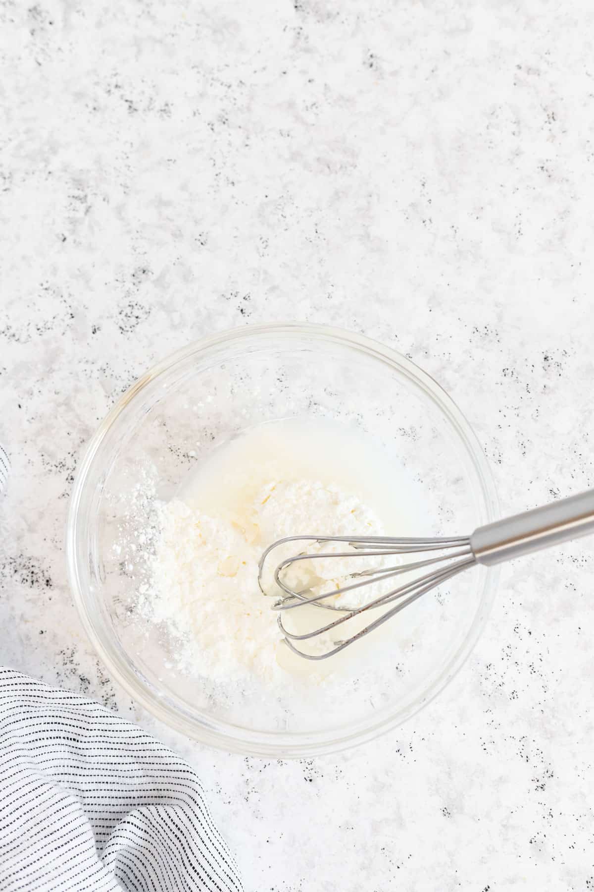 cornstarch and water in a bowl with a whisk