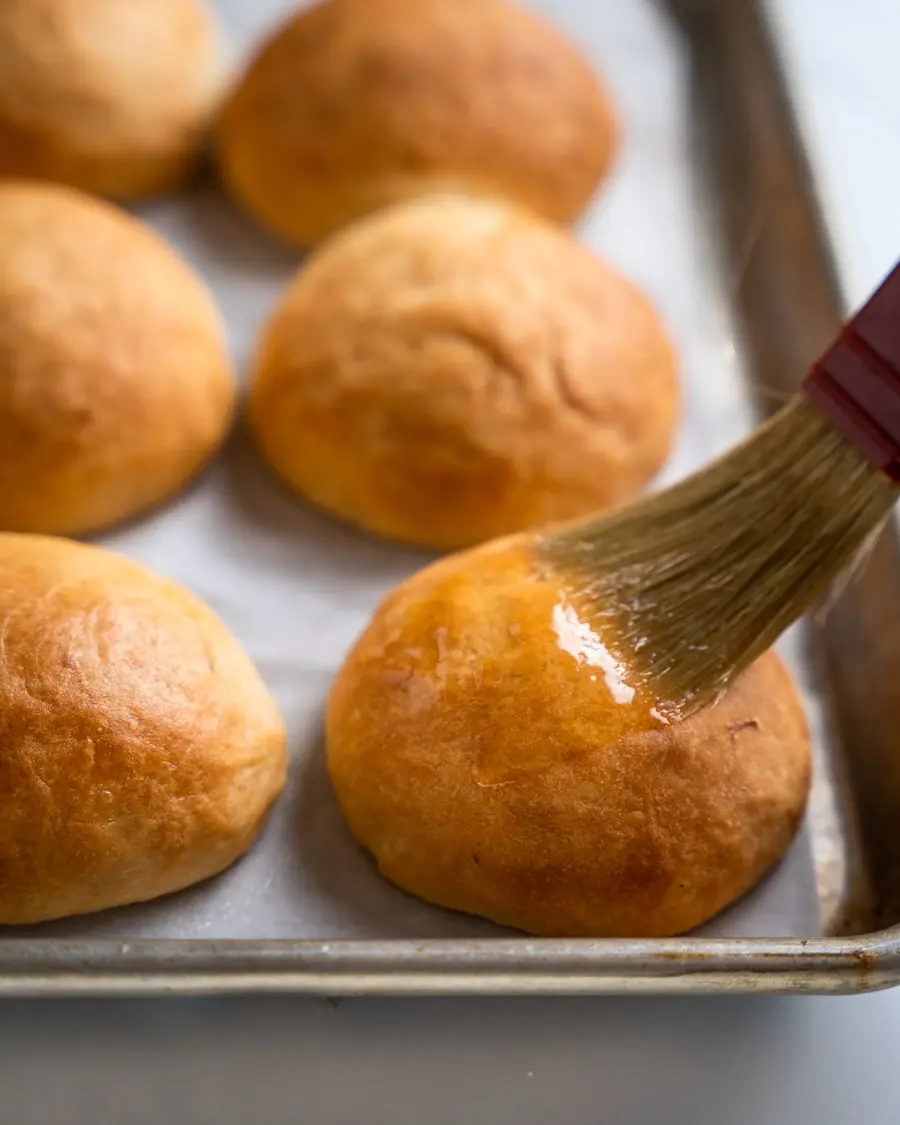 pastry brush with melted butter on potato rolls