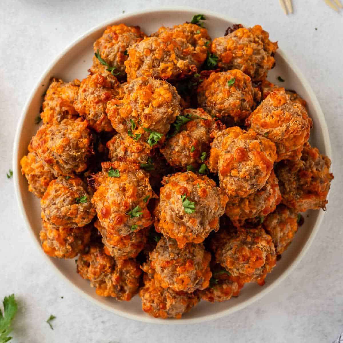 White bowl of sausage and cream cheese ball snacks. 