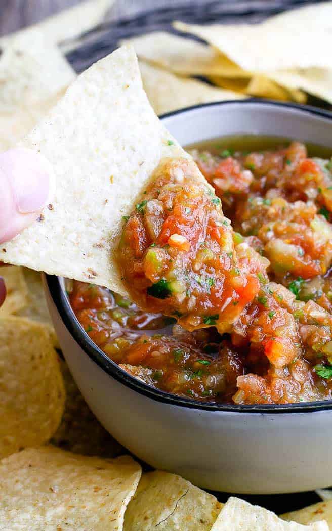 bowl of salsa with chip dipping in it
