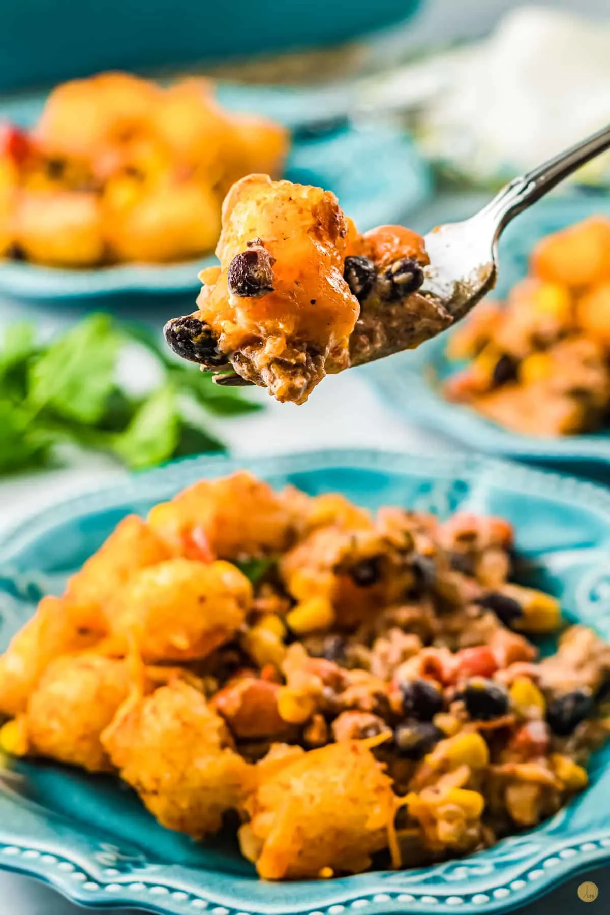 Cowboy casserole on a blue plate, with a forkful being lifted in mid-air.