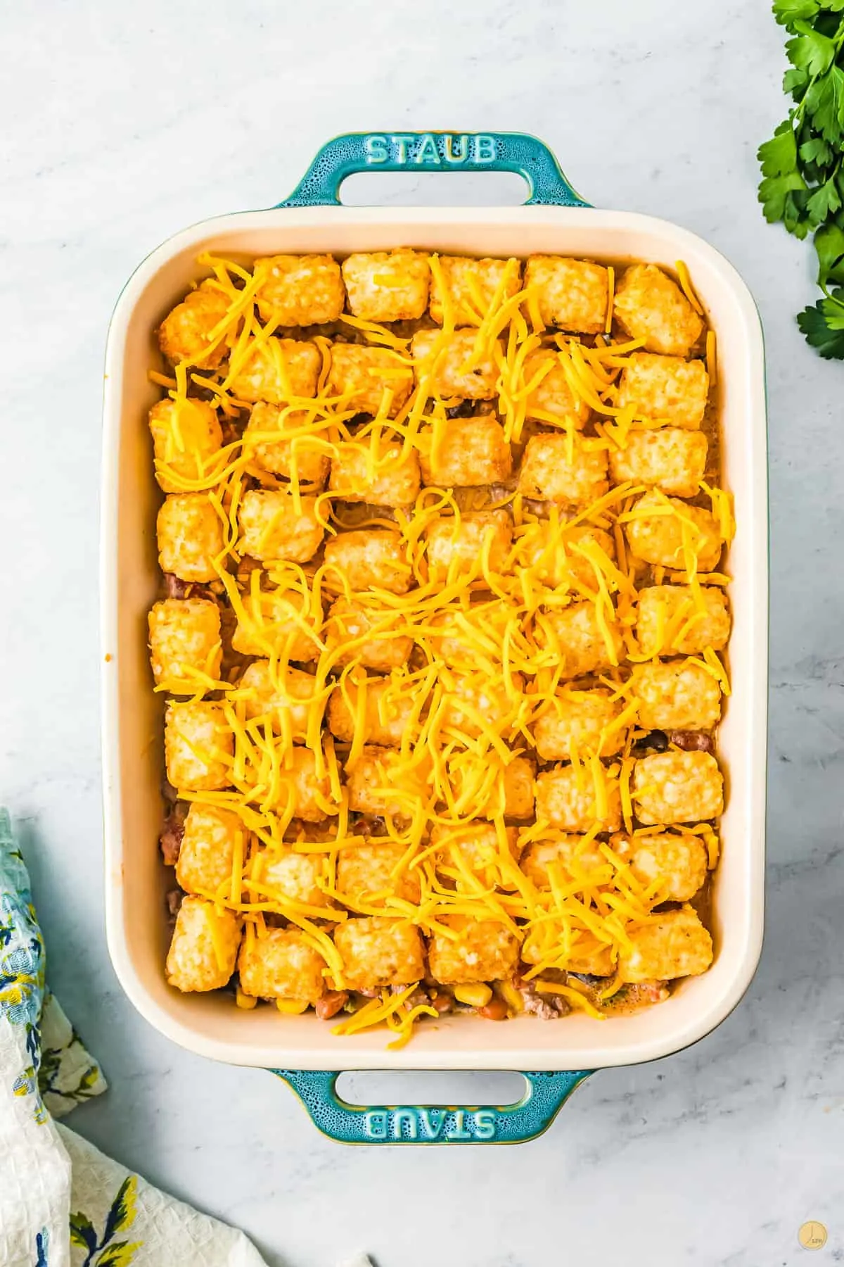 blue baking dish with tater tots and cheese